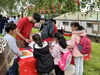Children standing around a table in a parc doing gelli printing