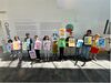 Children holding up prints that spell out ScrapAntics