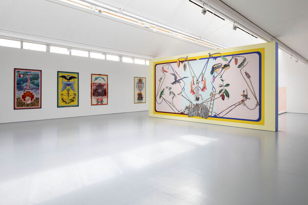 a white gallery space with colourful tuftings on the wall and bright mural in the centre