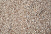 Photograph shows a close up of crushed materials in brownish pinkish fragments.