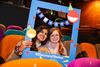 Two young women at Discovery Film Festival, holding a colourful selfie frame in the cinema
