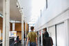 A man and woman walk towards DCA Box Office desk, looking up at the skylights