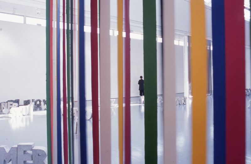 Colourful vertical strings of paper hang in front of DCA Gallery.