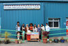 Members of teh Flourish Group and DCA Learning team standing outside Dundee International Women's Centre with an art cart filled with creative materials