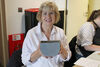 Craft Sunday attendee bolding their decorated ceramic hanging planter and smiling