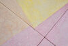 A floor based work is shown in gallery one. The walls are white and the gallery floor is painted grey. On top of this, a sculptural floor is lain in blocks, raising the floor over most of the gallery. This work is brightly coloured, with pastel blue green, yellow orange and pink, in abstract shapes.