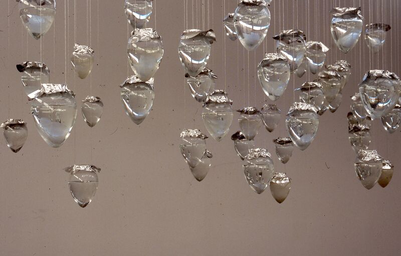Droplets made out of glass, with tinfoil on top hang from the ceiling.