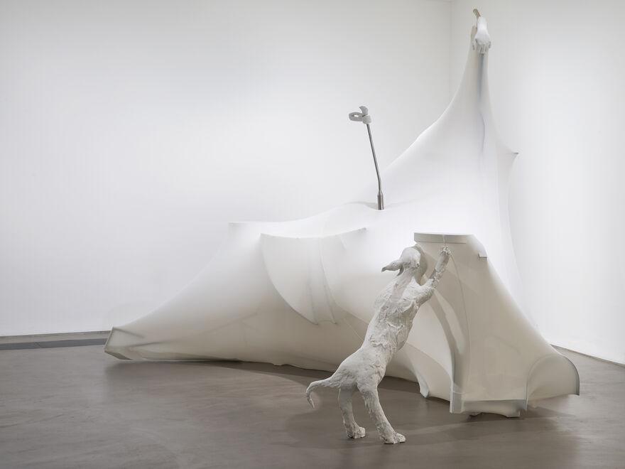 A large white sculpture in the corner with the image of a dog against the 