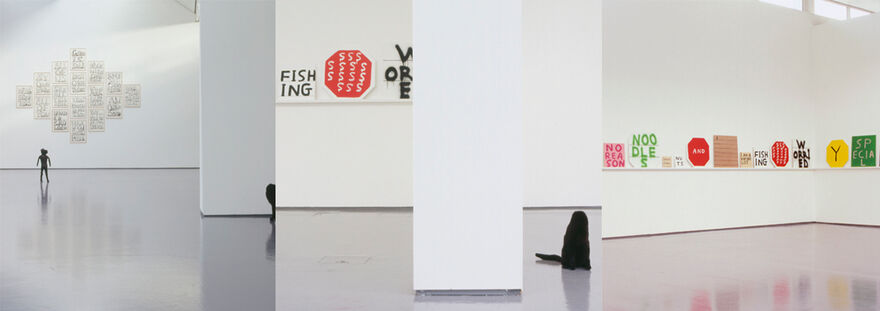 Images from David Shrigley's exhibition in DCA Galleries. A small statue of a man, and a headless cat. On the walls, there are canvases with graffiti slogans written on them.