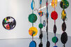 Artwork from Rachel Eulena Williams's exhibition. Large, colourful circular painted vines hang and a colourful circular canvas can be seen in the background.